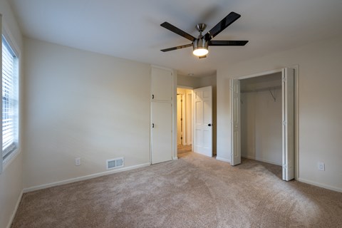 a living room with carpet and a ceiling fan